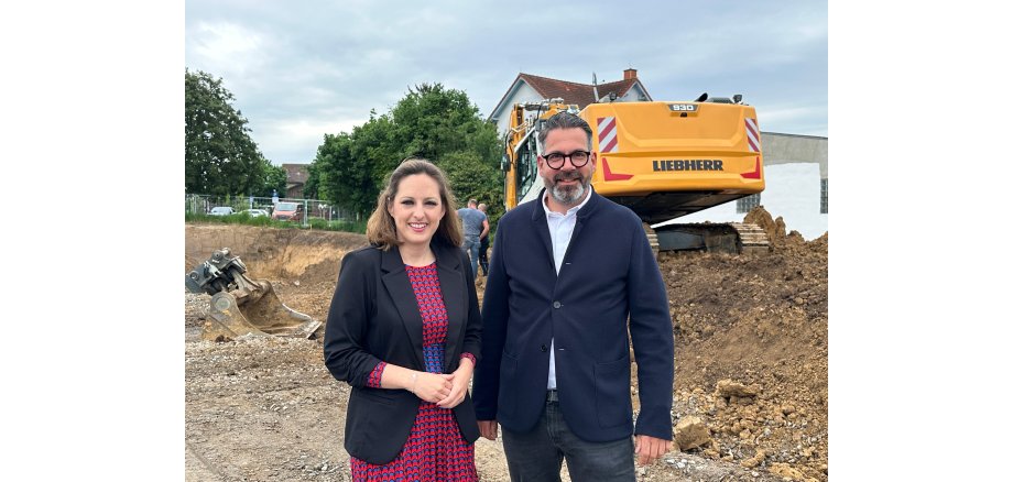 Im Vordergrund Lena Herget, Bürgermeisterin Reichelsheim und Michael Schmale, Geschäftsführer raab.schmale GmbH. Im Hintergrund die Baustelle in Reichelsheim 